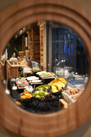 A buffet setup with various food items and a glass display case. - La Suite Boutique Hotel (Tirana)