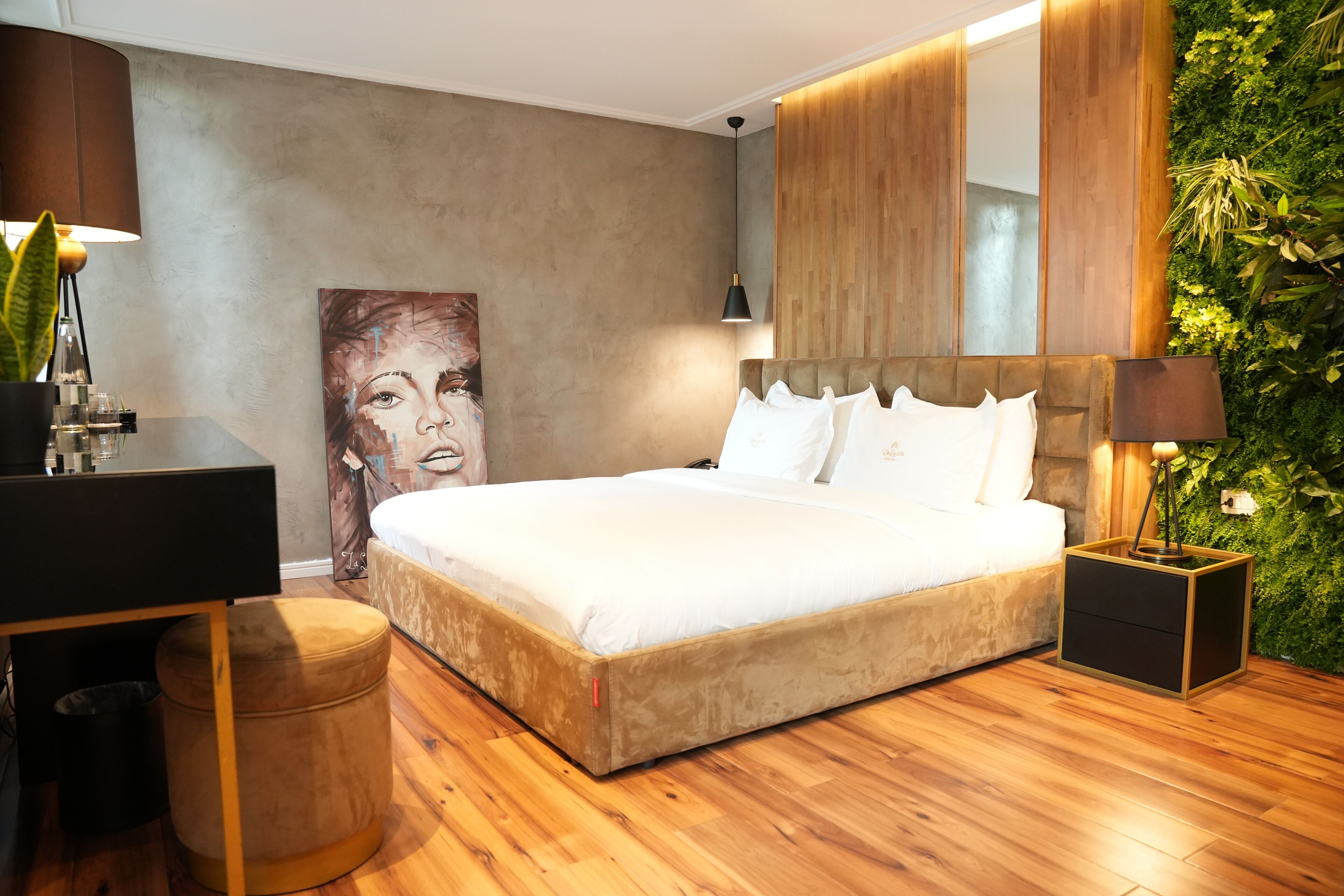 Un dormitorio moderno con una cama grande, un escritorio y un taburete pequeño.