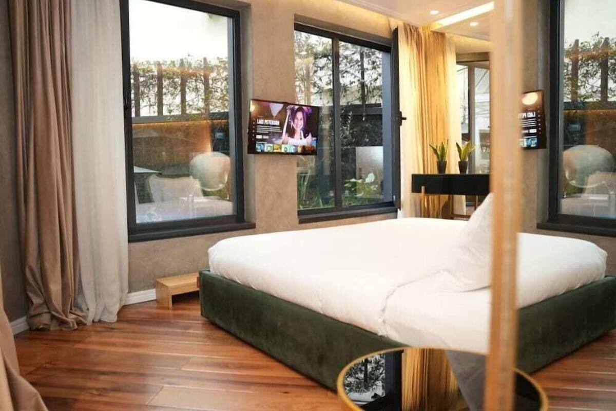 Une chambre d’hôtel moderne avec un grand lit, une télévision et une vue sur l’extérieur.