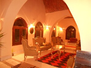 Uma área de estar acolhedora com piso xadrez, móveis elegantes e janelas em arco.