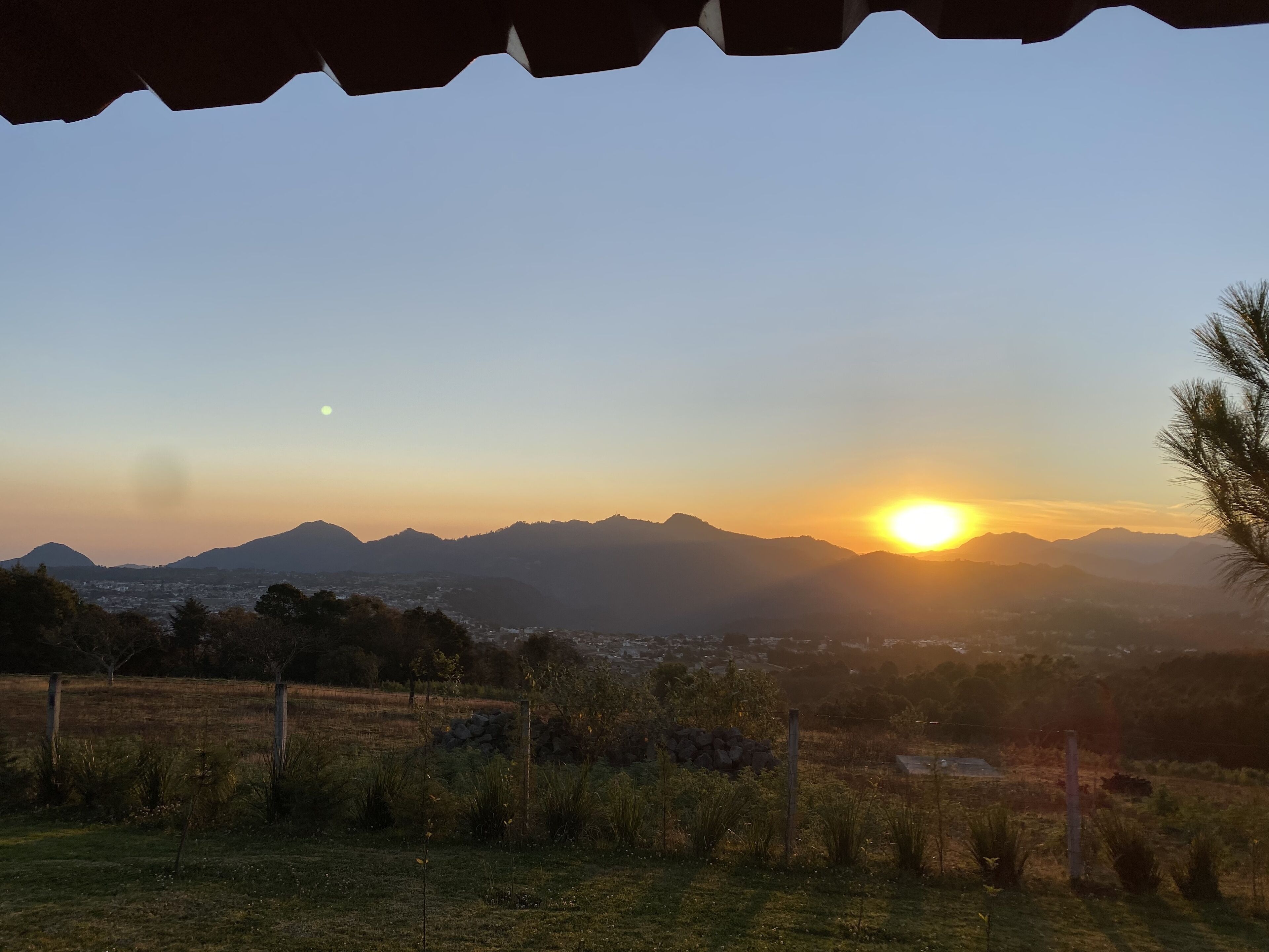 A sunset over a mountainous landscape with a view of a town below.