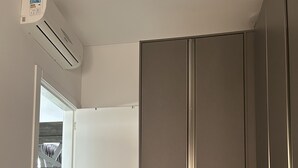 Ein Schlafzimmer mit einem Bett, einem Kleiderschrank und einer Klimaanlage.