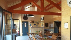 A wooden interior with a dining area, tables, and chairs.