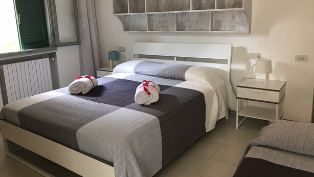 A hotel room with a bed, a nightstand, a lamp, and a window with curtains. - Il Colibrì house with garden (Carrara)