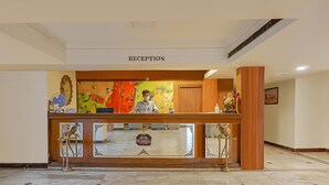A reception area with a wooden counter, a clock, and a sign that reads "RECEPTION". - Kumar Resort by Turtle, Lonavala (Mawal)