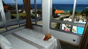 A bedroom with a large window overlooking a pool and the sea. - Marola (Sanxenxo)
