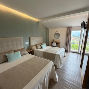 A hotel room with two beds, a bedside table with a lamp, a mirror, and a TV mounted on the wall. - Marola (Sanxenxo)