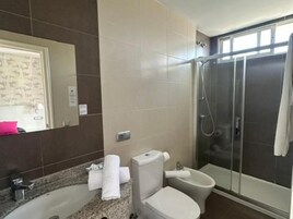 Un baño con ducha, inodoro y lavabo.