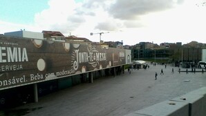 A public square with a large advertisement for a beer brand. - Metro-Apartment - Porto (Porto)