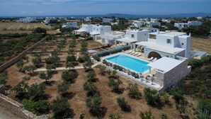 Ein Küstenresort mit weißen Gebäuden, einem Swimmingpool und Blick auf das Meer.