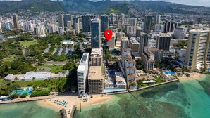 Eine Luftaufnahme einer Küstenstadt mit Hochhäusern, einem Strand und einem Hotel mit Pool.