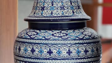 A ceramic vase with a geometric pattern, placed on a wooden surface.