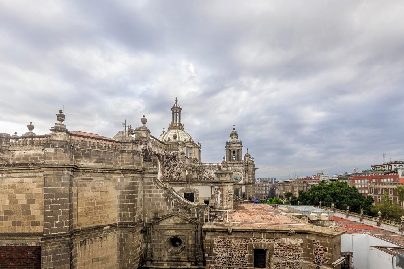 A historic building with a prominent dome and bell tower, surrounded by urban structures.