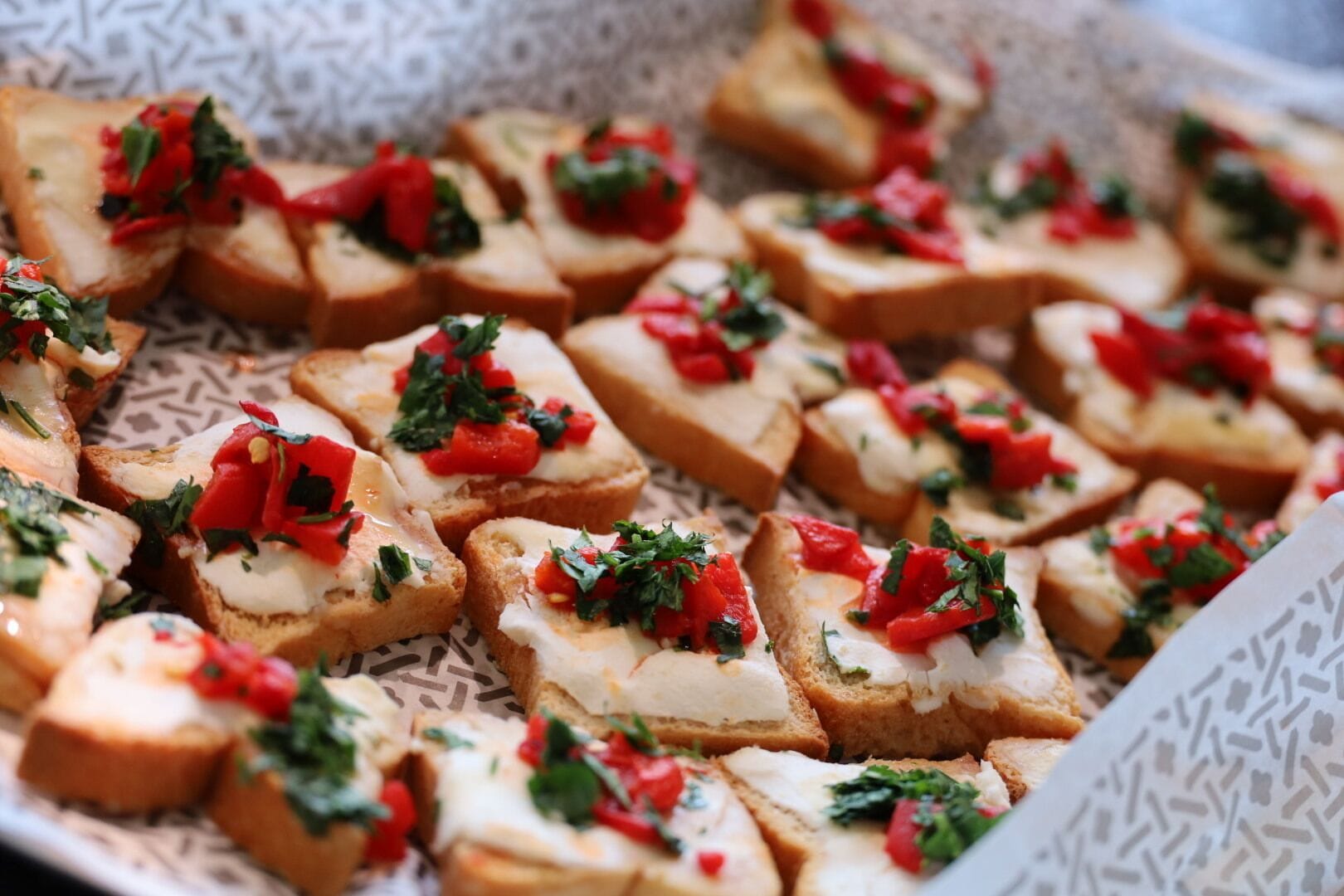 A tray of bruschetta with toppings.