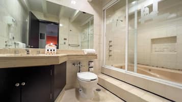 Un baño moderno con inodoro, lavabo y zona de ducha.