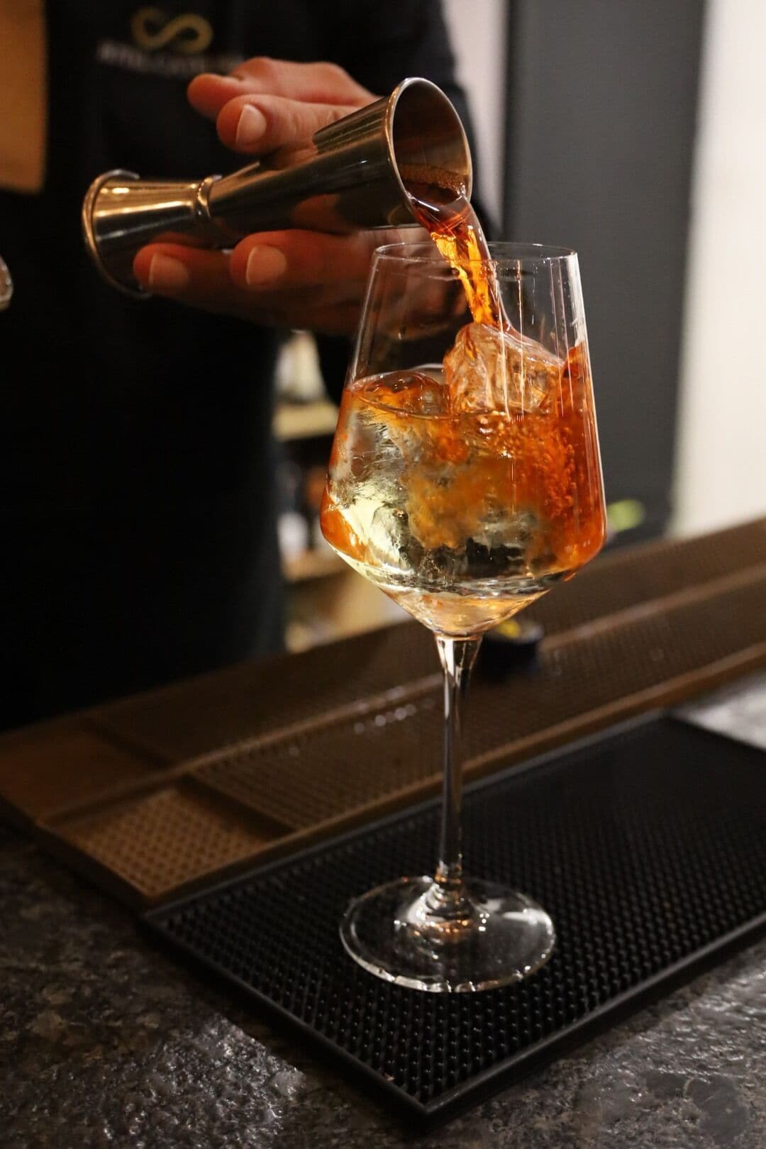 Un bartender sirve una bebida en un vaso.