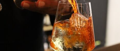 Un bartender sirve una bebida en un vaso.