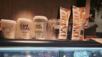 Eine Auswahl an Kaffeetassen und Gebäck in der Bäckereiecke eines Cafés.