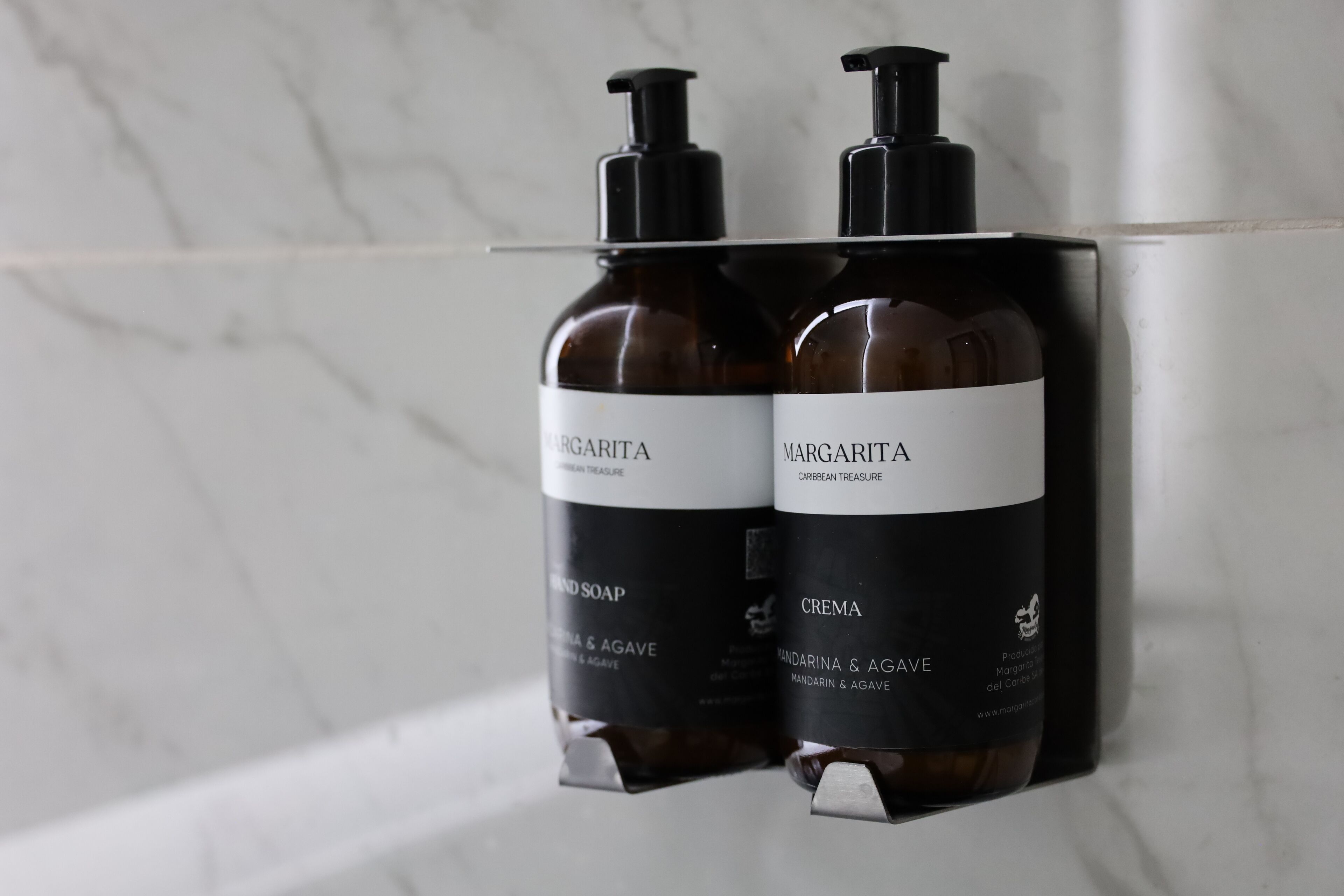 Dos botellas de jabón y crema de Margarita en un baño.