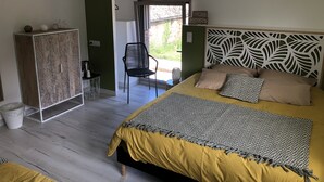Une chambre à coucher avec un lit, une chaise, une armoire et une vue sur l’extérieur.
