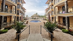 A resort with a central pool, multiple balconies, and outdoor seating areas. - Beachfront Jaco Condos - Fully Equipped - 6 Pax (Jacó)