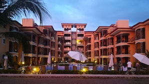 A hotel with multiple balconies, outdoor seating, and a pool area. - Beachfront Jaco Condos - Fully Equipped - 6 Pax (Jacó)
