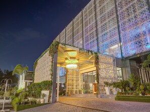 A modern building with a patterned facade, a covered entrance, and well-maintained landscaping. - Palette - City Westend (New Delhi)