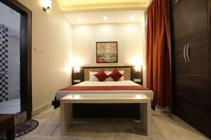 Una habitación de hotel con una cama, lámparas de noche, un cuadro en la pared y un armario.