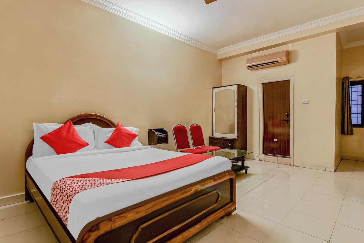 Une chambre d’hôtel avec un grand lit, une armoire, un miroir et un appareil de climatisation.