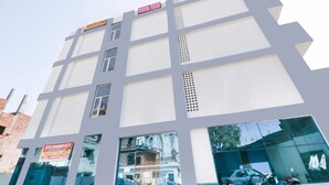 A multi-story hotel with a modern architectural design, featuring large windows and a prominent signboard. - OYO 43300 Spring Woods Suites (Mohali)