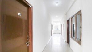 A corridor with a wooden door labeled '101' and a window with a wooden frame. - OYO 43300 Spring Woods Suites (Mohali)