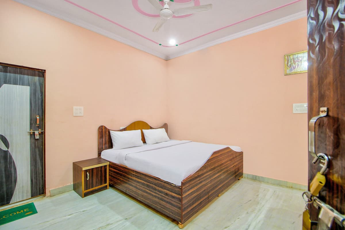 A bedroom with a wooden bed, a nightstand, a ceiling fan, and a door with a padlock.