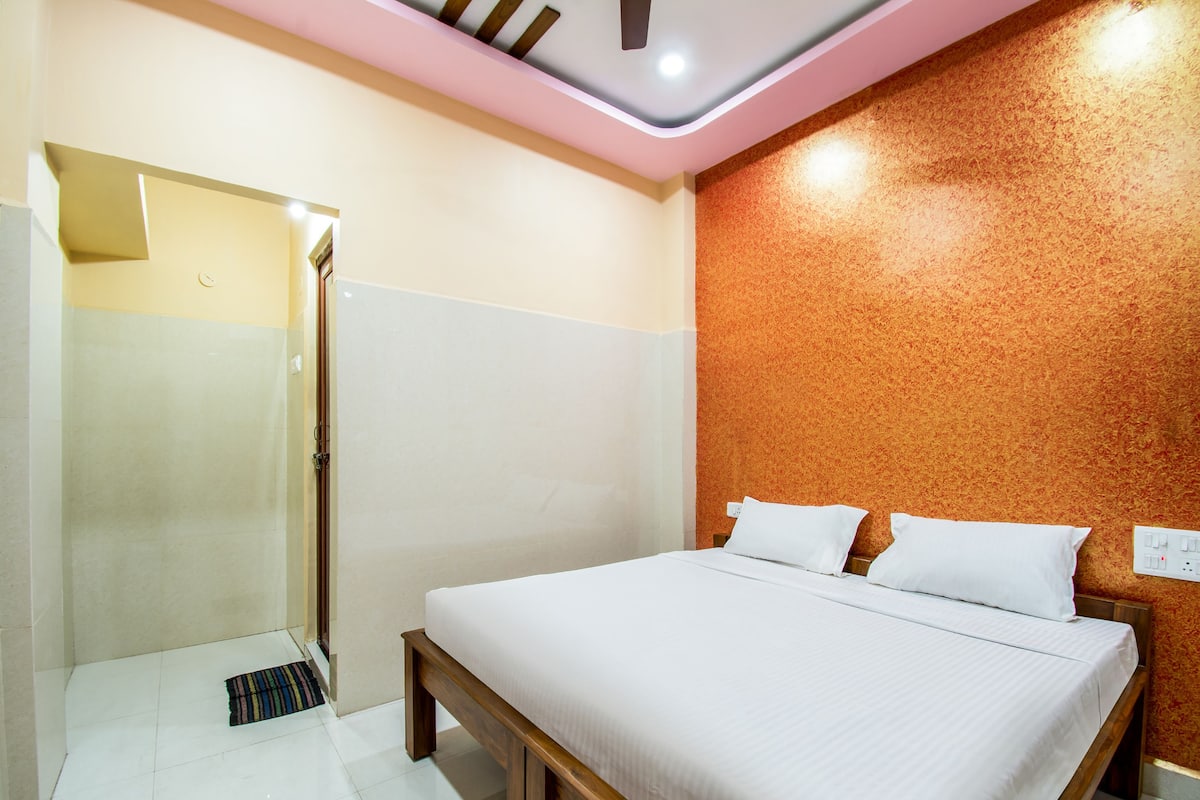 Een hotelkamer met een bed, een douche en een wand met een structuur.