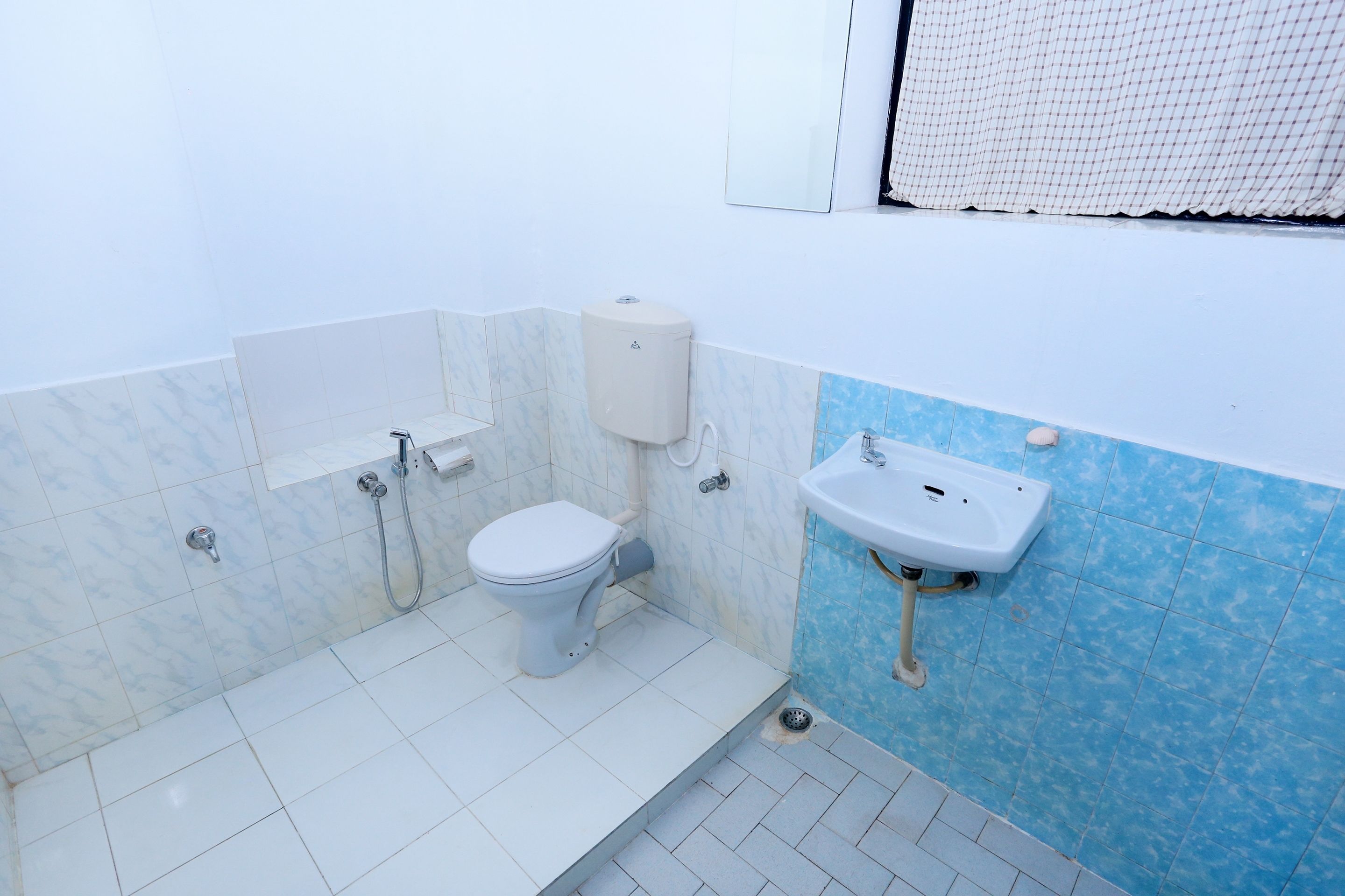 A small bathroom with a toilet, sink, and shower.