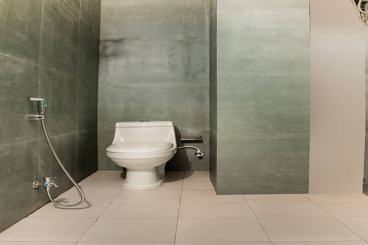 Un baño pequeño y moderno con inodoro, ducha y perchero para toallas.