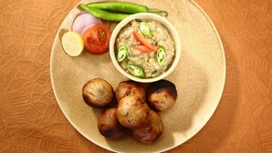 A plate with a bowl of soup, some bread rolls, and fresh vegetables. - OYO Flagship 23420 Patliputra Heritage Guest House (Patna)