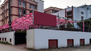 A building with a white facade, a red door, and a pink awning. - OYO Flagship 23420 Patliputra Heritage Guest House (Patna)