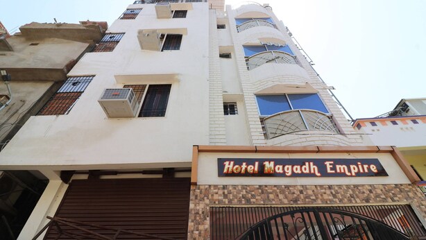 Een meerlaags gebouw met een bord waarop 'Hotel Magadh Empire' staat.