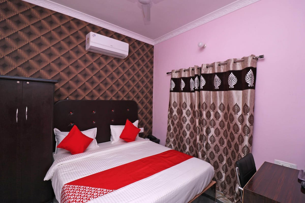 Une chambre bien rangée, avec un lit, une armoire, un bureau et un rideau à motifs.