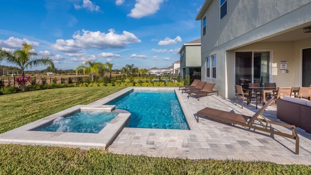 A swimming pool with lounge chairs and a patio area. - Diamond Villa (Kissimmee)