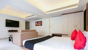 Une chambre d’hôtel moderne dotée d’un grand lit, d’une télévision à écran plat, d’un canapé et d’une armoire.