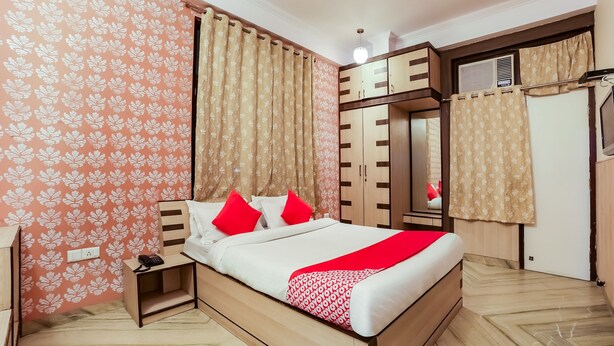 Un dormitorio con cama, mesita de noche, armario y espejo.