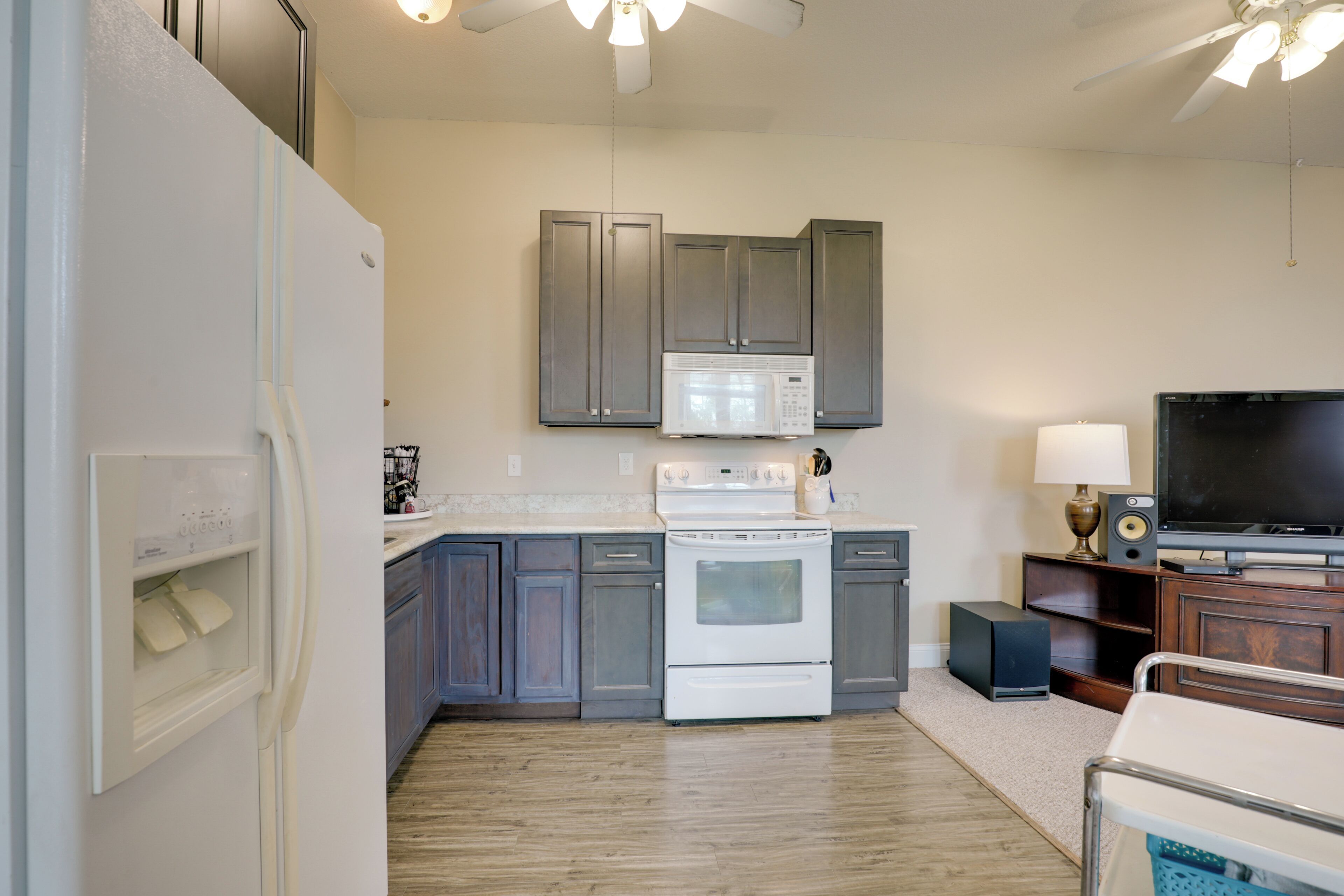 A modern kitchen with a refrigerator, microwave, stove, and cabinets.