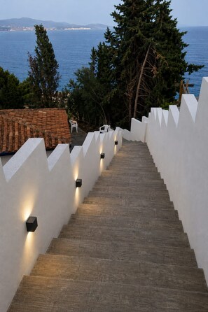 A staircase leading to a terrace with a view of the sea, white walls, and a tiled roof. - pretty house with wonderful sea view wifi available throughout the property (Spagna)