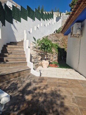 A staircase leading to a stone wall with a potted plant and a hose. - pretty house with wonderful sea view wifi available throughout the property (Spagna)