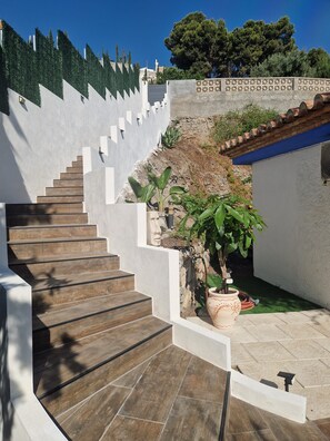 Eine Treppe führt zu einer Dachterrasse mit Blick auf die umliegende Landschaft.