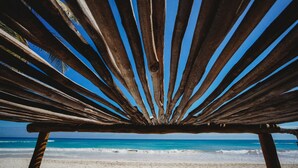 A wooden beach chair with a view of the ocean. - Casa Mandala (Tulum)