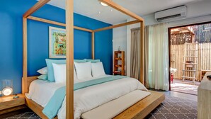 A four-poster bed with a wooden frame, a blue wall, and a wooden floor. - Villa Amalfi (Tulum)
