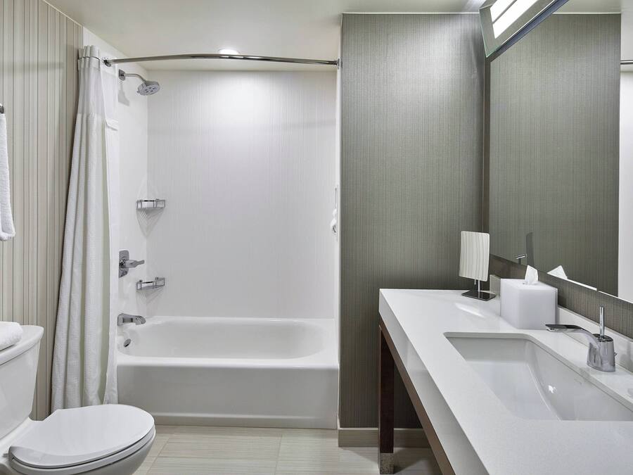 A modern bathroom with a bathtub, a toilet, and a sink.