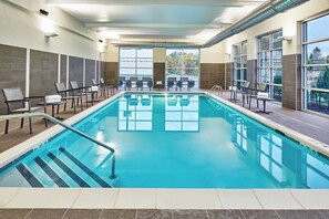 An indoor swimming pool with clear water, tiled walls, and large windows offering views of trees and a distant structure. - Courtyard by Marriott Albany Airport (Albany)
